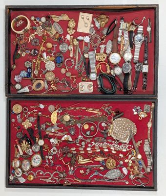 two wooden boxes filled with assorted jewelry on a red surface