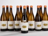six bouteilles de vin sont alignées sur une surface blanche