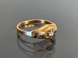 an image of a gold and diamond ring on a black surface
