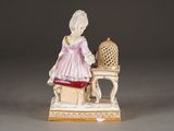 a figurine of a woman sitting at a table
