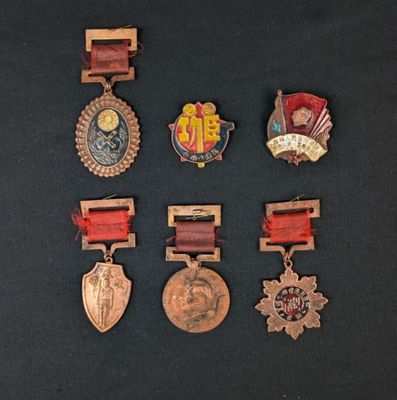 several medals are displayed on a black surface with a black background