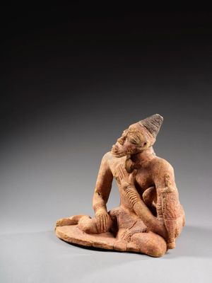 une statue représentant un homme assis sur un rocher, coiffé d'un chapeau
