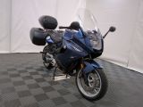 une moto bleue garée sur un sol à damier