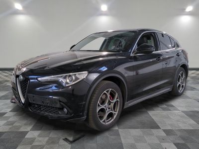 un SUV Alfa noir garé sur un sol à damier dans un garage
