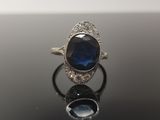 un gros plan d'une bague sertie d'une pierre bleue