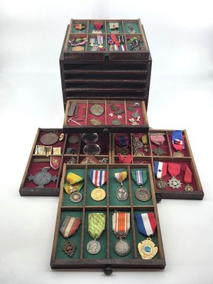 a wooden box filled with medals and other items