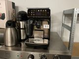 a coffee maker and a coffee pot sitting on a counter