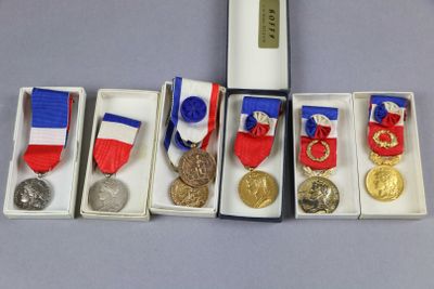 cinq médailles et une médaille dans une boîte posée sur une table