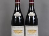 two bottles of wine sitting on top of a table next to each other