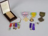 an assortment of medals including a cross, medal, and other items