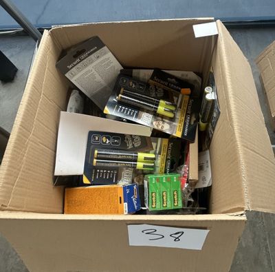 une boîte en carton remplie de piles et des piles par terre