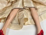 a doll that is wearing a dress and red shoes