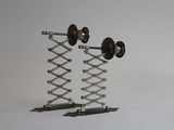 une sculpture métallique représentant une paire d'haltères posée sur un socle