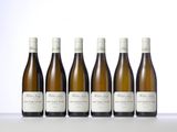 six bottles of white wine lined up on a table