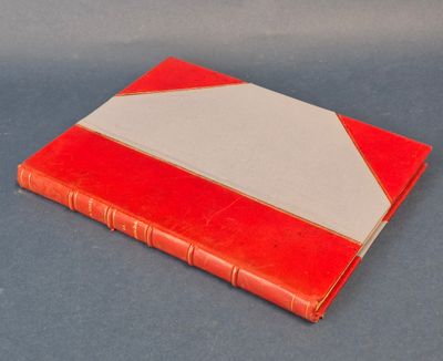 un vieux livre rouge et blanc posé sur une table bleue