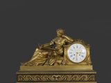 une horloge en or avec une femme assise dessus
