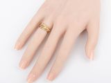 the woman ' s hand is holding a gold ring on her finger