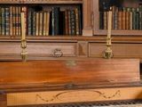 un piano devant une bibliothèque dans une bibliothèque