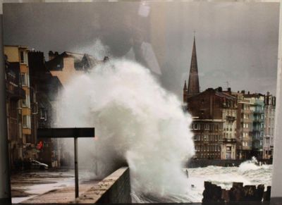 une photo montrant une grande vague déferlant sur un mur