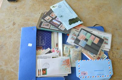 une valise remplie de courrier et d'autres objets, posée par terre