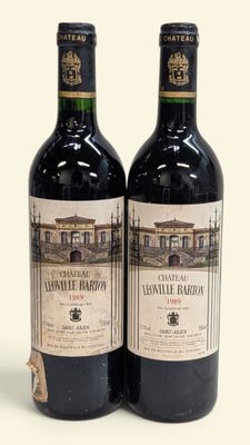 deux bouteilles de vin posées l'une à côté de l'autre sur une surface blanche