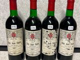 three bottles of red wine are lined up on a counter