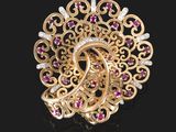 un gros plan d'une broche en or sertie de rubis et de diamants