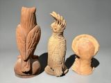 three clay sculptures of birds sitting on top of each other