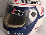 the helmet of a race car driver sits on a white surface