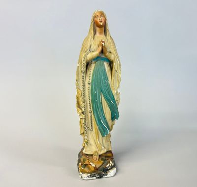 a statue of a woman holding a rosary in her hands