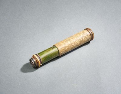 un gros plan d'un petit tube de bambou posé sur une surface grise