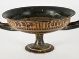 a black and gold bowl with a handle on it