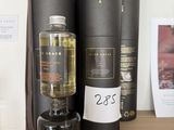 une bouteille d'alcool posée sur une table à côté de quelques livres