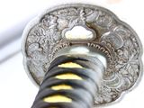 a close up of a sword with a yellow stripe on it