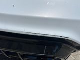 a close up of the front of a car with a dent on it