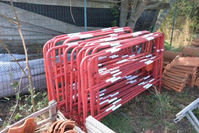 a pile of red metal pipes sitting in the grass