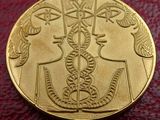 une pièce d'or sur laquelle figurent deux personnes