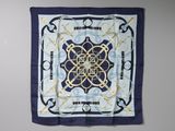 a blue and white square scarf with a design on it