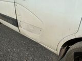 a white van with a broken door on the side of the road