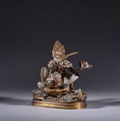 une figurine en bronze représentant une femme avec un oiseau et des fleurs