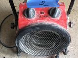 a red and black heater sitting on the floor