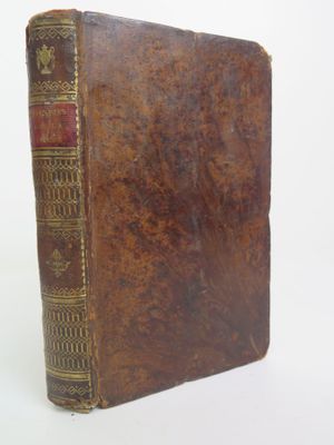 un vieux livre à la couverture brune posé sur une table