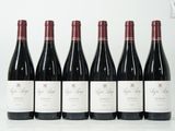 six bouteilles de vin rouge sont alignées sur une table