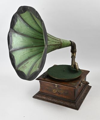 un gramophone vert et noir posé sur un socle en bois