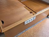 a wooden bed with a drawer underneath it on the floor