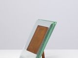 une photo représentant un cadre en verre posé sur une table blanche