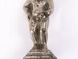 une petite figurine en argent posée au sommet d'un poteau métallique