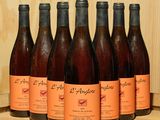 six bouteilles de vin sont alignées sur une étagère en bois