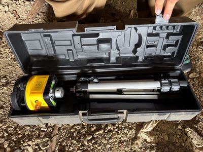 a person holding a tool in a case on the ground