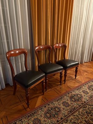 trois chaises placées devant un rideau dans une pièce
